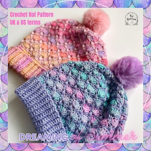 Könnte beinhalten: Zwei Häkelmützen mit einem farbenfrohen Ombre-Design. Die Mützen sind mit einem strukturierten Stich gearbeitet und haben flauschige Bommel. Der Text "DREAMING of Summer" steht unter den Mützen.