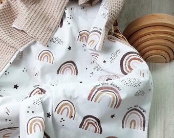 May include: A white baby blanket with a rainbow pattern and the text "You are magic" and "Follow your dreams". The blanket is made of soft cotton and is perfect for cuddling.