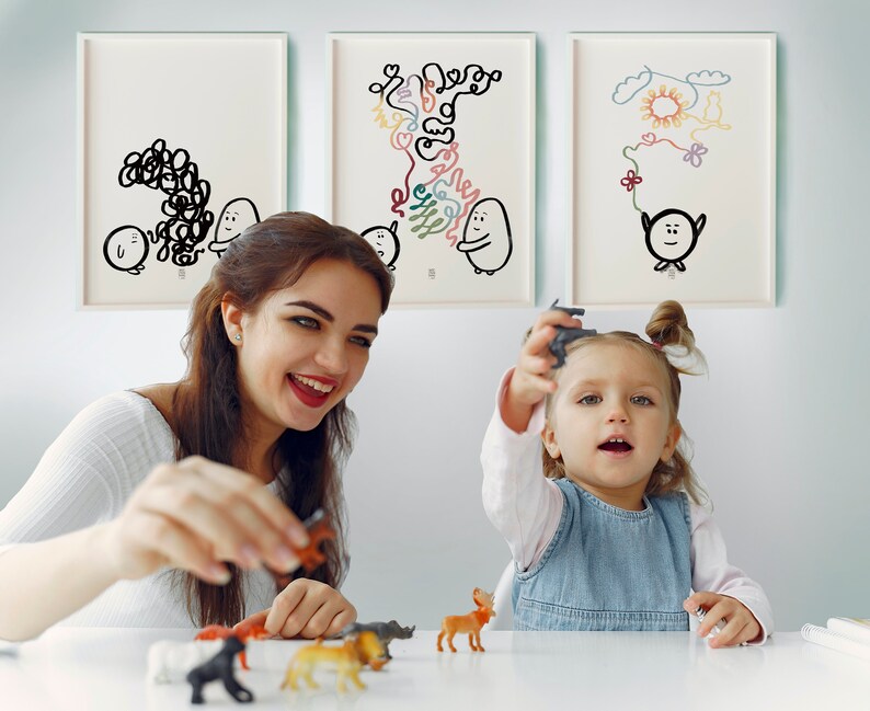 May include: A woman and a young girl are playing with toy animals. The girl is holding a grey toy aeroplane. The woman is holding a brown toy animal. There are three framed drawings on the wall behind them.