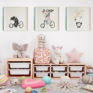May include: A children's playroom with a white wall, three framed black and white drawings, a wooden shelf with white drawers, and various stuffed animals including an elephant, a unicorn, an octopus, and a lion. The shelf is filled with colourful balls and toys.