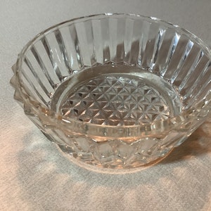 Puede incluir: Un tazón de vidrio transparente con un patrón de diamante en el fondo y crestas verticales alrededor de los lados.