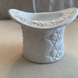 May include: White milk glass hat shaped vase with a diamond pattern.
