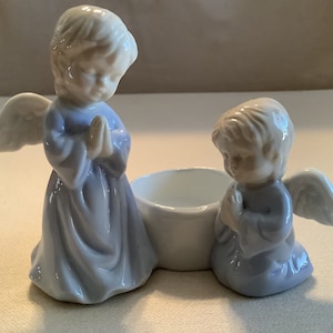 Vintage unknown manufacturer white ceramic tea light candle holder with two kissing angels dressed in blue