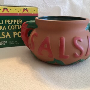 May include: Terracotta salsa pot with red chili pepper handles and the word "SALSA" in pink lettering.