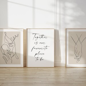May include: Three framed prints with minimalist line art designs. The left print features a woman's face, the middle print has the text "Together is our favourite place to be", and the right print shows two hands holding each other.