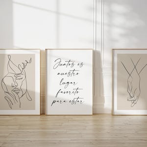 Puede incluir: Tres impresiones minimalistas de arte de línea en marcos de madera. La impresión de la izquierda presenta un dibujo de línea de una cara. La impresión del centro presenta el texto "Juntos es nuestro lugar favorito para estar". La impresión de la derecha presenta un dibujo de línea de dos manos que se sostienen.