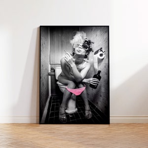 May include: Black and white photograph of a person sitting on a toilet in a bathroom. The person is wearing sunglasses and has their hair in rollers. They are smoking a cigarette and holding a bottle of alcohol.