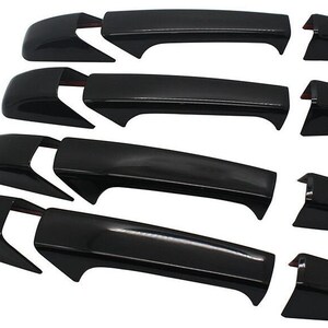 May include: Set of four black exterior door handles for a car. The handles are made of plastic and have a smooth, glossy finish.