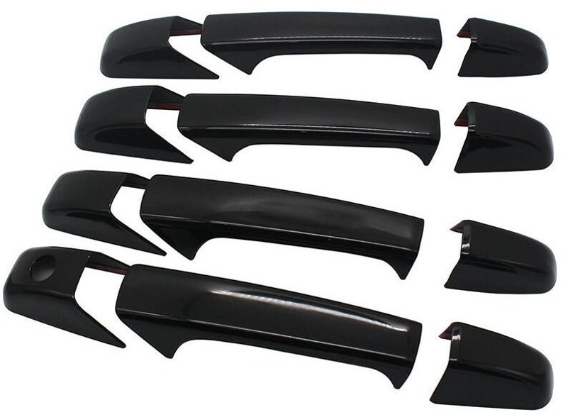 May include: Set of four black exterior door handles for a car. The handles are made of plastic and have a smooth, glossy finish.