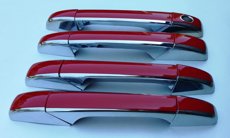 May include: Four red car door handles with chrome accents. The handles are arranged in a row, with the top handle being the furthest away from the viewer.