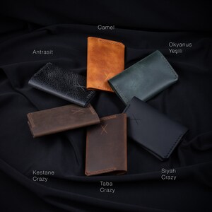 May include: Six leather wallets in different colors and textures, including camel, antrasit, kestane crazy, taba crazy, siyah crazy, and okyanus yesili.