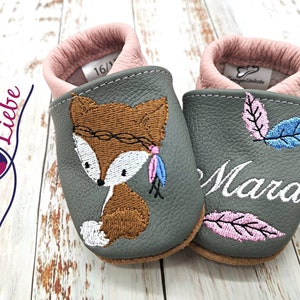 a pair of baby shoes with a picture of a fox