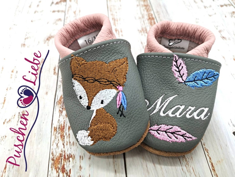 a pair of baby shoes with a picture of a fox