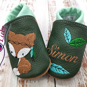 a pair of baby shoes with a fox on them