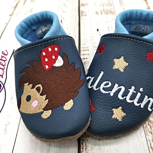 a pair of baby shoes with a bear on them