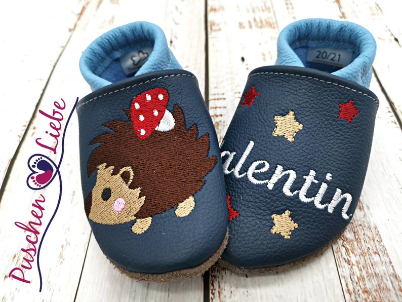 a pair of baby shoes with a bear on them