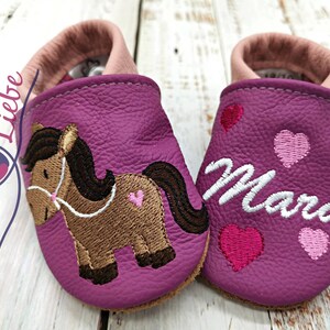 a pair of baby shoes with a horse on them