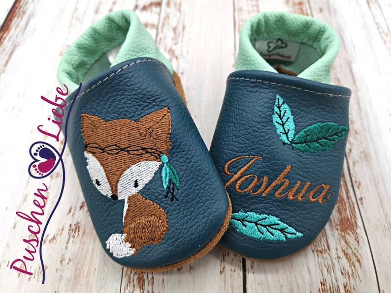 a pair of baby shoes with a fox on them