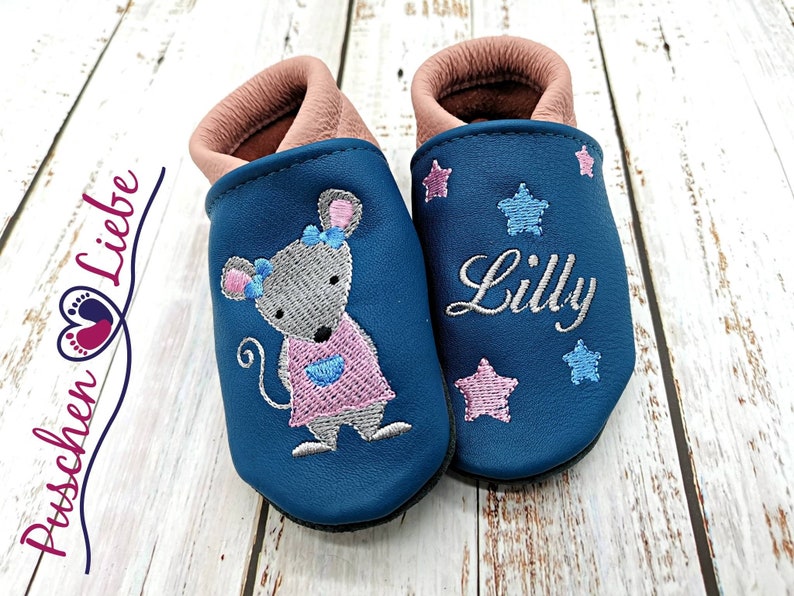 a pair of baby shoes with a mouse on them