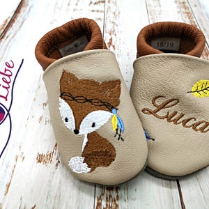 a pair of baby shoes with a picture of a fox