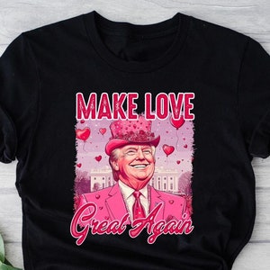 May include: Black t-shirt featuring a pink and white illustration of a man wearing a top hat with hearts and the text "Make Love Great Again".