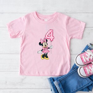 K&ouml;nnte beinhalten: Eine wei&szlig;e Keramik-Tasse mit schwarzem Henkel und dem Text "But First, Coffee" in fetter, schwarzer Schrift. Die Tasse steht vor einem verschwommenen Hintergrund, der eine gem&uuml;tliche Umgebung andeutet.