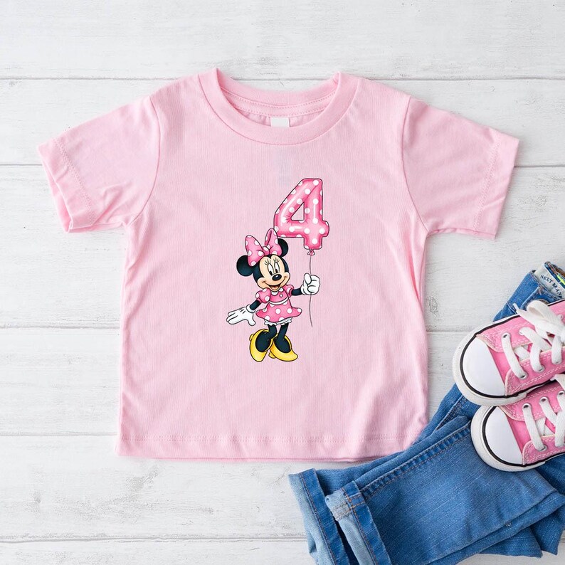 K&ouml;nnte beinhalten: Eine wei&szlig;e Keramik-Tasse mit schwarzem Henkel und dem Text "But First, Coffee" in fetter, schwarzer Schrift. Die Tasse steht vor einem verschwommenen Hintergrund, der eine gem&uuml;tliche Umgebung andeutet.