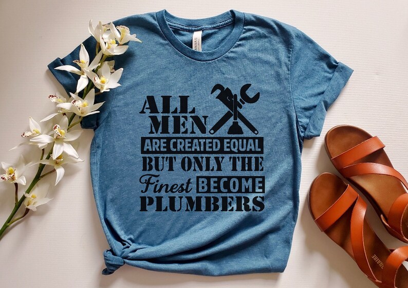 May include: A blue t-shirt with a black graphic that reads "All men are created equal but only the finest become plumbers". The graphic also includes a wrench and a plunger.