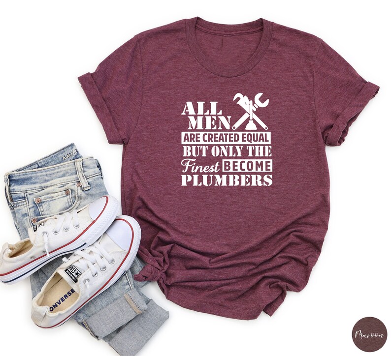 May include: A maroon t-shirt with white text that reads "All men are created equal but only the finest become plumbers". The text is accompanied by a graphic of crossed wrenches.