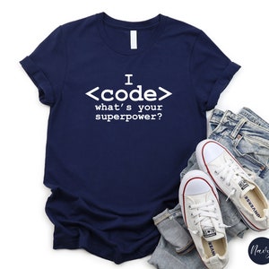 May include: A navy blue t-shirt with white text that reads "I <code> what's your superpower?"