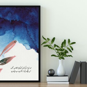 May include: A framed watercolour painting with a blue and pink colour scheme. The painting features a stylised branch with leaves and a quote in Urdu script. The quote reads: "میری زندگی میں کوئی چیز ٹھکانہ پر نہیں بس تجھے دیکھ کہ لگتا ہے سب اچھا ہے"