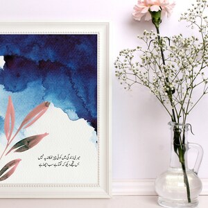 May include: A framed watercolour painting with a blue and pink colour scheme. The painting features a stylised branch with leaves and a quote in Urdu script. The quote reads: "میری زندگی میں کوئی چیز ٹھکانہ پہ نہیں اس تجھے دیکھ کہ لگتا ہے سب اچھا ہے"