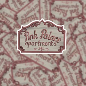 May include: A vintage-style sign with a pink and white color scheme. The sign reads "Pink Palace Apartments" in a decorative script font.
