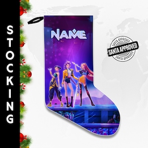 May include: A Christmas stocking featuring a vibrant illustration of three animated figures on a stage, with the word "NAME" above them. The stocking has a black loop for hanging and a "SANTA APPROVED" stamp.