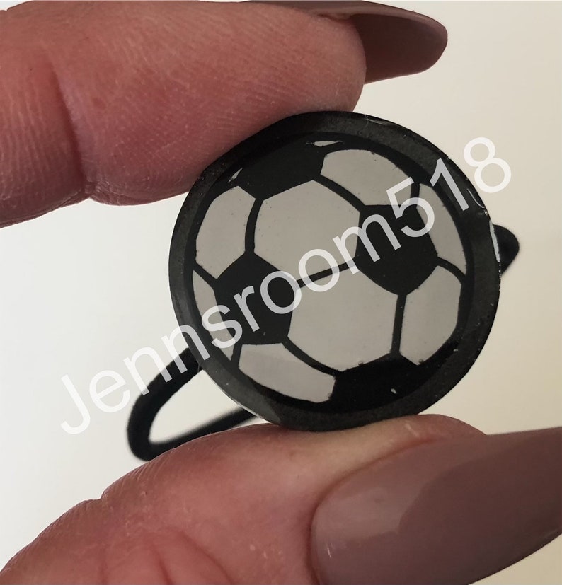 May include: Black hair tie with a white and black soccer ball design.
