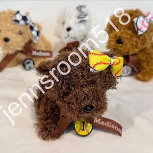 May include: Three plush toy dogs with different colored fur and bows. The dogs are wearing name tags that say "Madison".