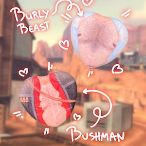 Może przedstawiać: Dwie pluszowe zabawki w kształcie serca z ilustracjami owłosionej klatki piersiowej i tułowia w czerwonym stroju. Teksty "Burly Beast" i "Bushman" są napisane zabawną czcionką, z grafiką serca i strzałki.