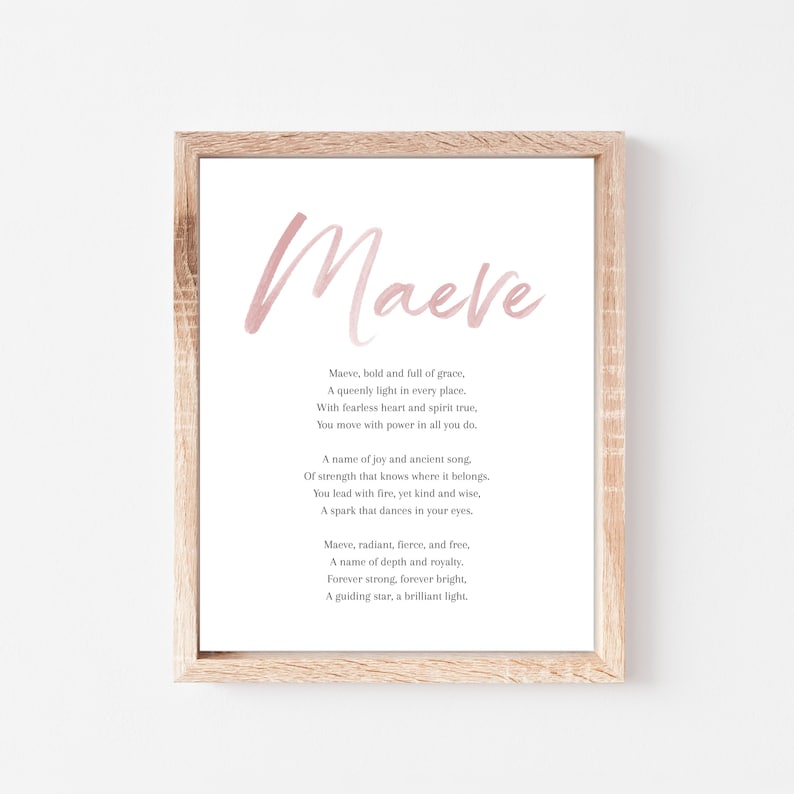 May include: A framed print featuring the name "Maeve" in a soft pink watercolor font. The print includes a poem about the name Maeve in a classic serif font, set against a white background. The frame is a light wood color.