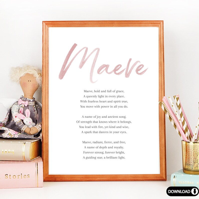 May include: A framed print with the name "Maeve" in a soft pink watercolor font. The print includes a poem about the name Maeve. A doll and books are next to the framed print.