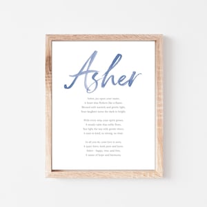 May include: A framed print featuring the name "Asher" in blue watercolor script. Below the name is a poem about Asher. The frame is made of light-colored wood, and the background is white.