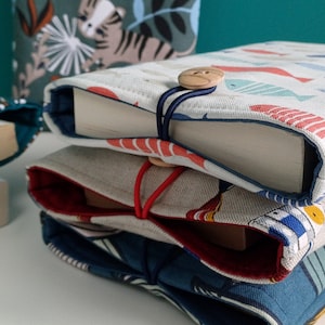 Pochette livre molletonnée fermeture avec bouton 2 tailles et plusieurs imprimés