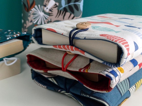 Pochette livre molletonnée fermeture avec bouton 2 tailles et plusieurs imprimés