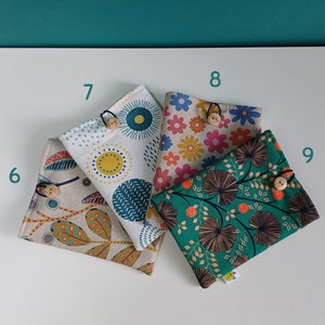 Puede incluir: Cuatro bolsas de tela con diferentes patrones florales y geom&eacute;tricos. Cada bolsa tiene un cierre de bot&oacute;n de madera. Las bolsas est&aacute;n dispuestas en forma de cuadrado sobre una superficie blanca.