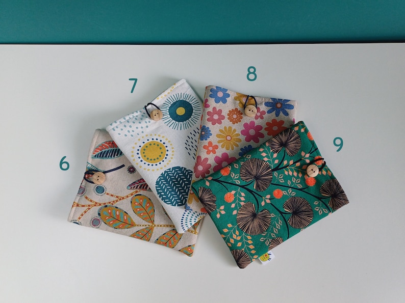 Puede incluir: Cuatro bolsas de tela con diferentes patrones florales y geom&eacute;tricos. Cada bolsa tiene un cierre de bot&oacute;n de madera. Las bolsas est&aacute;n dispuestas en forma de cuadrado sobre una superficie blanca.