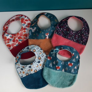 Peut inclure: Cinq bavoirs pour bébé colorés avec différents motifs. Les bavoirs sont faits d'un matériau doux et absorbant et ont un dos en éponge. Les motifs comprennent des animaux, des fleurs et des formes géométriques.