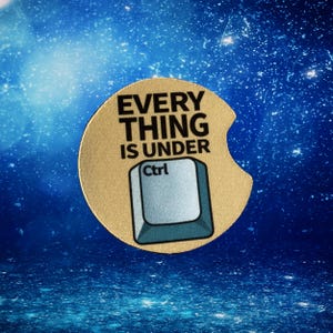 May include: A tan car coaster with the text "EVERYTHING IS UNDER Ctrl" and a graphic of a computer Ctrl key. The coaster has a curved cutout for easy removal and placement in a car cup holder.
