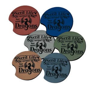 May include: Six round, brown, gray, blue, and green coasters with a black dragon and the text "Nerd Life like normal life but with Dragons" printed on them.