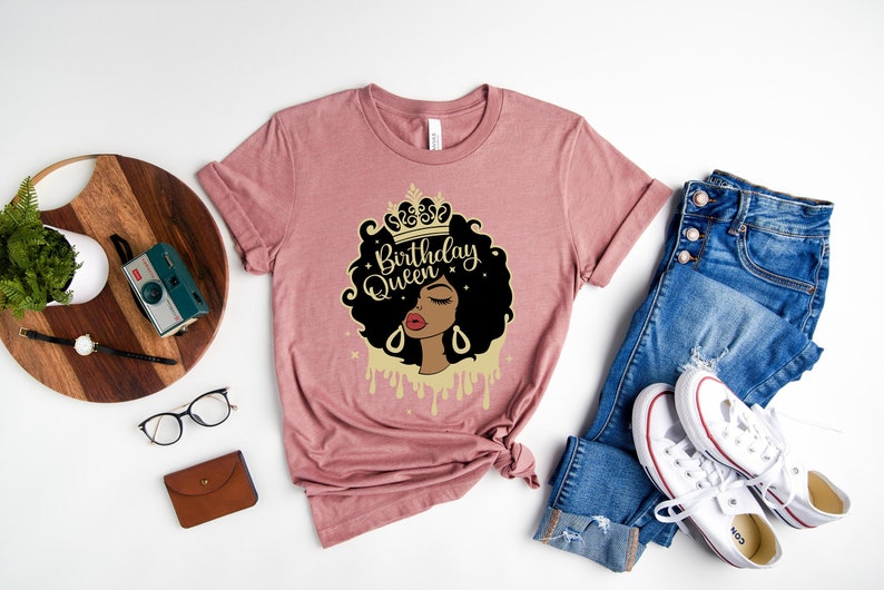 May include: A pink t-shirt with a graphic of a black woman with a crown and the text "Birthday Queen".