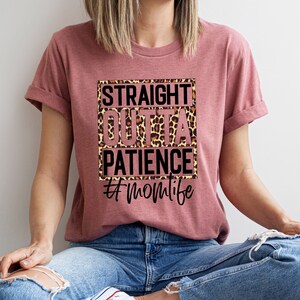 Op de afbeelding: Een roze T-shirt met een luipaardprint en de tekst "Straight Outta Patience #MomLife" erop gedrukt.
