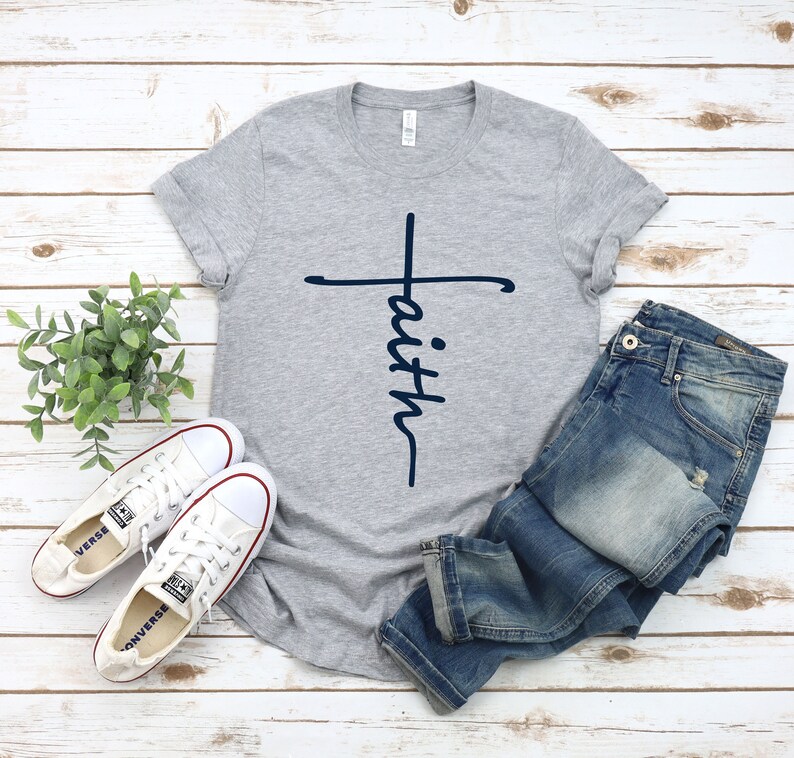 May include: A gray t-shirt with a navy blue cross and the word "faith" written vertically on the cross.